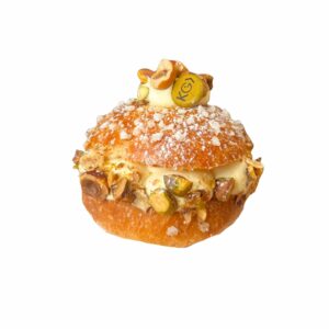 Une pâtisserie dorée, garnie de crème et de pistaches, signée L’A Pâtisserie KG